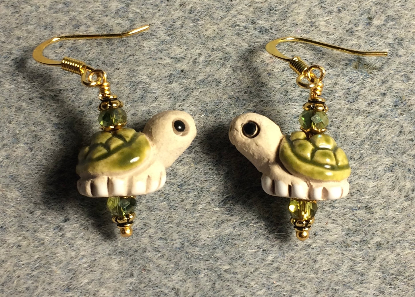 Small tan and olive green ceramic turtle bead earrings adorned with olive green Chinese crystal beads.