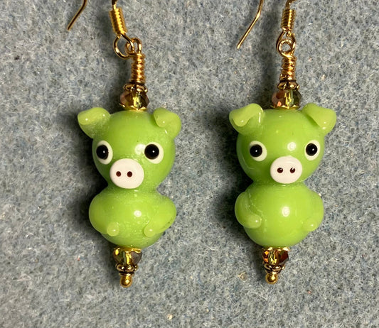 Olive green lamp work standing pig bead earrings adorned with olive green Chinese crystal beads.