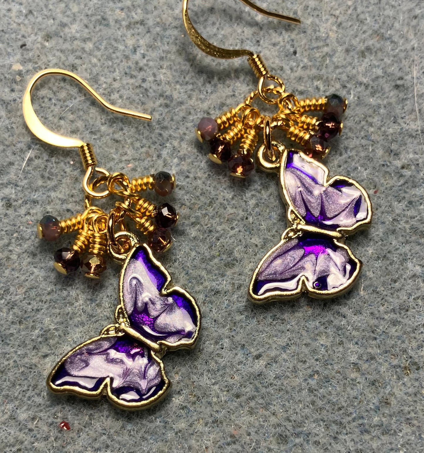 Purple and violet enamel butterfly charm earrings adorned with tiny dangling purple and violet Chinese crystal beads.