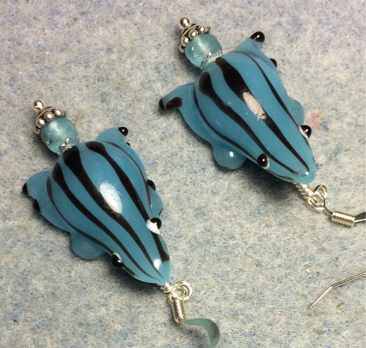 Light aqua with black stripes lamp work frog bead earrings adorned with light aqua Czech glass beads.