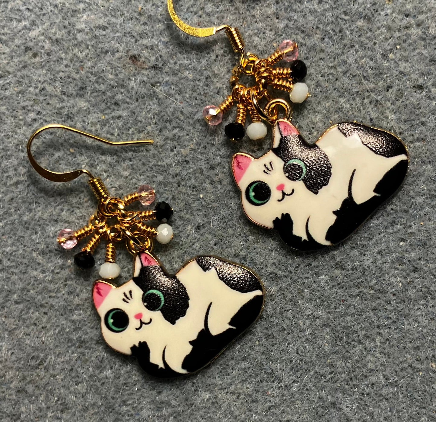 Black, white, and pink enamel cat charm earrings adorned with tiny dangling black, white, and pink Chinese crystal beads.