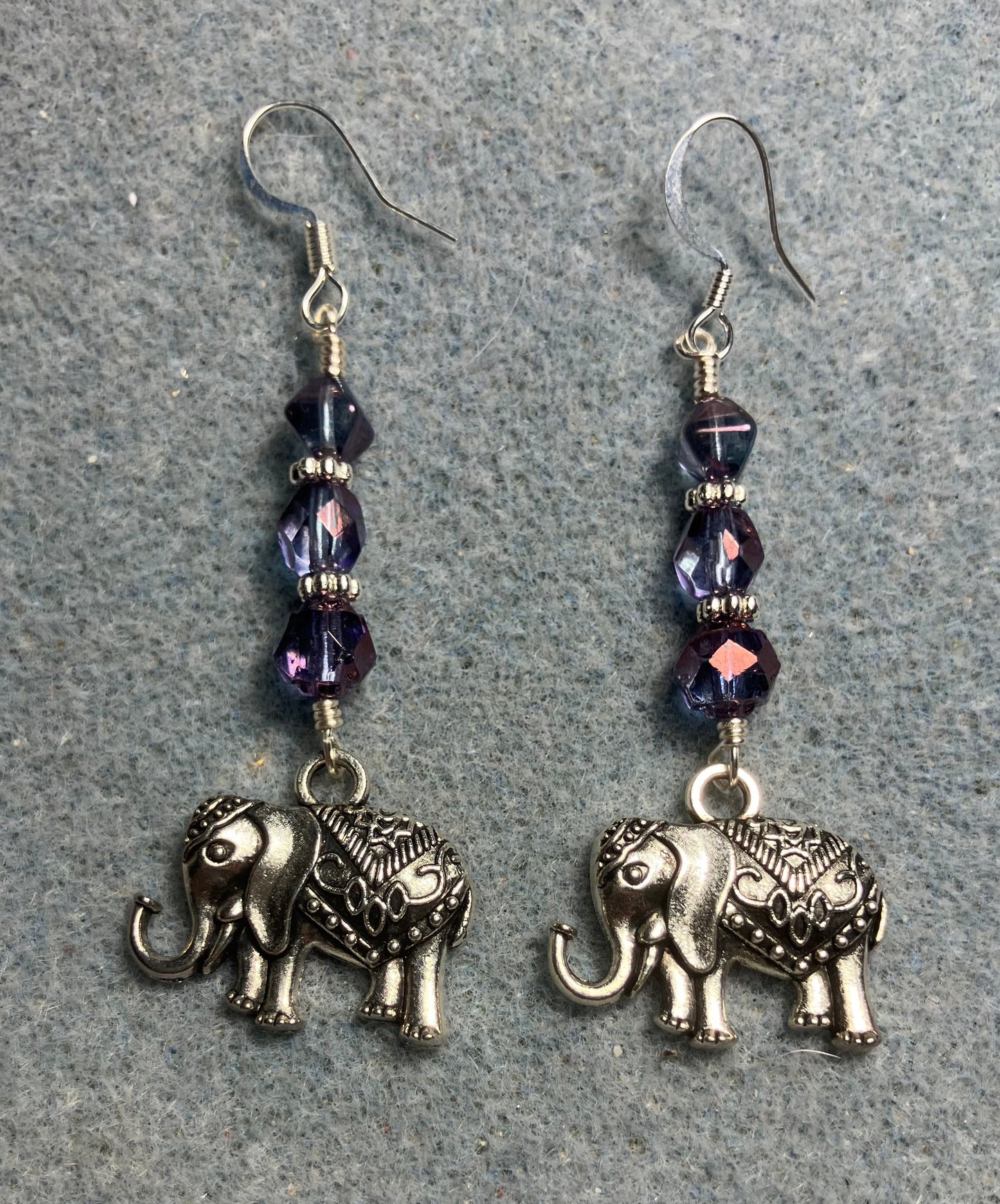 Ornate silver elephant charm earrings adorned with violet Czech glass beads.