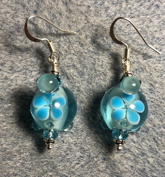 Light turquoise lamp work turtle bead earrings adorned with light turquoise Chinese crystal beads.