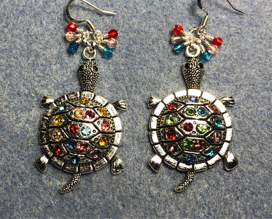 Large silver and colorful rhinestone turtle charm earrings adorned with small dangling red, clear, and turquoise Czech glass beads.