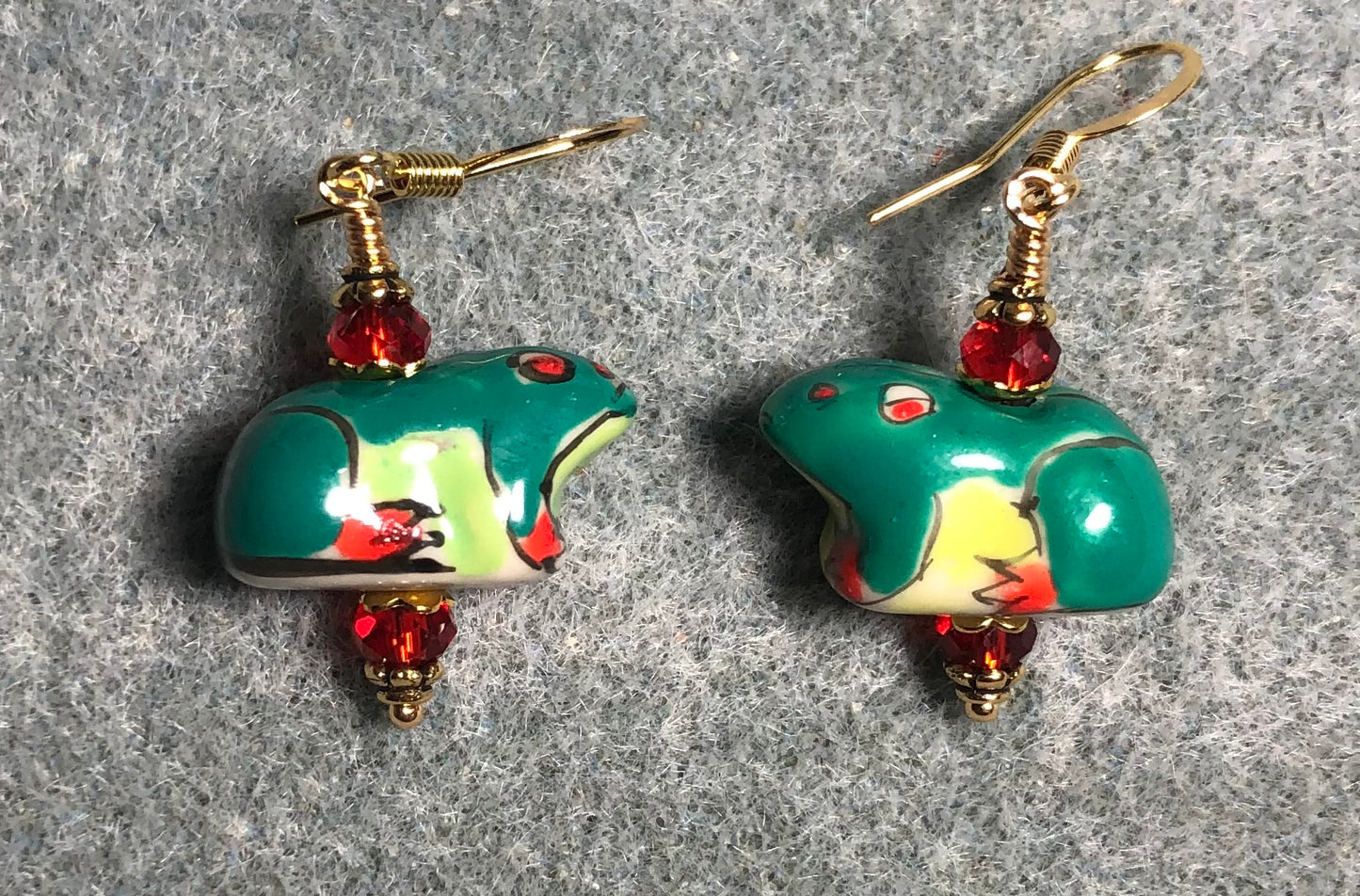 Dark green, red, and yellow ceramic frog bead earrings adorned with red Chinese crystal beads.