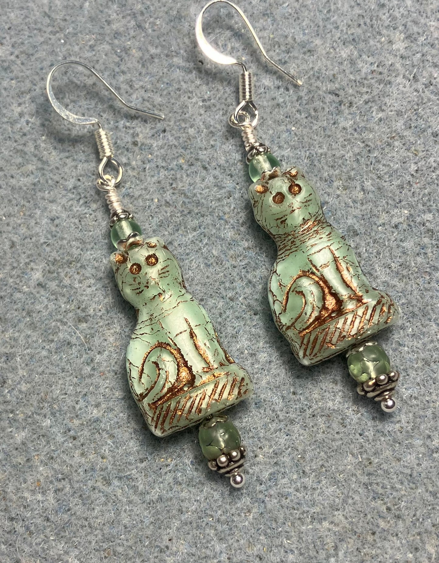 Light green (with copper inlay) fancy Czech glass fancy cat bead earrings adorned with light green Czech glass beads.