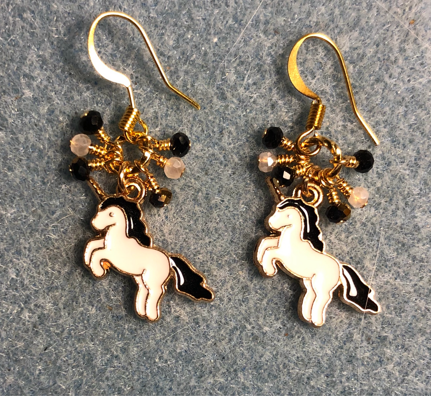 Small black and white enamel unicorn charm earrings adorned with tiny dangling black and white Chinese crystal beads.