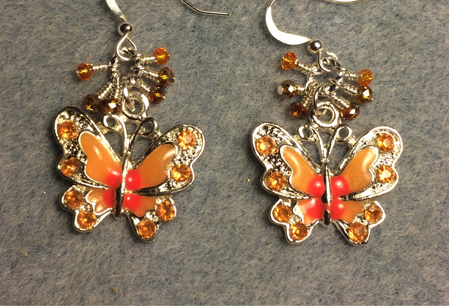 Silver, orange, and peach enamel and rhinestone butterfly charm earrings adorned with tiny dangling orange and peach Chinese crystal beads.