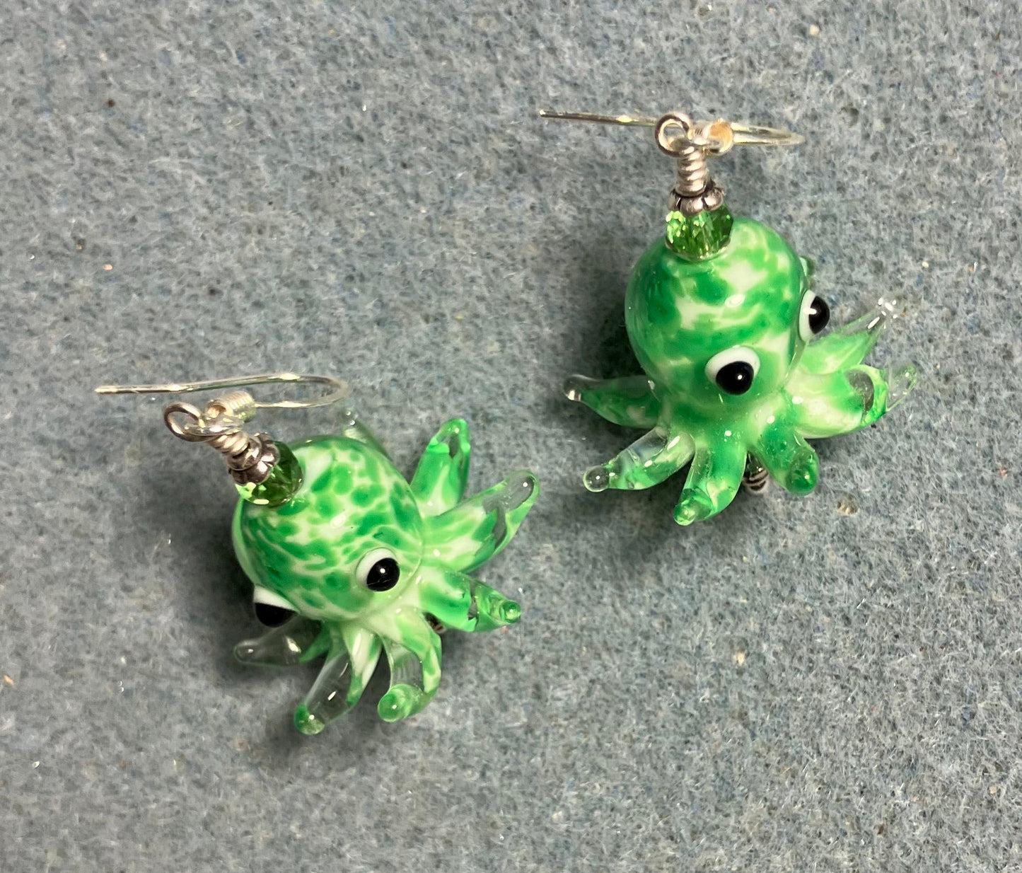 Green and white mottled lamp work octopus bead earrings adorned with green Chinese crystal beads.