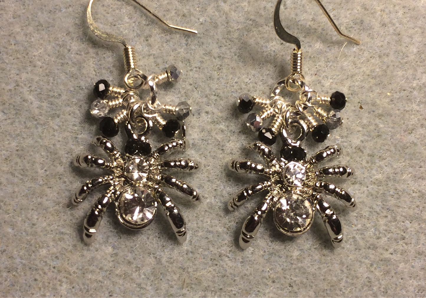 Silver and clear rhinestone spider charm earrings adorned with tiny dangling black and silver Chinese crystal beads.