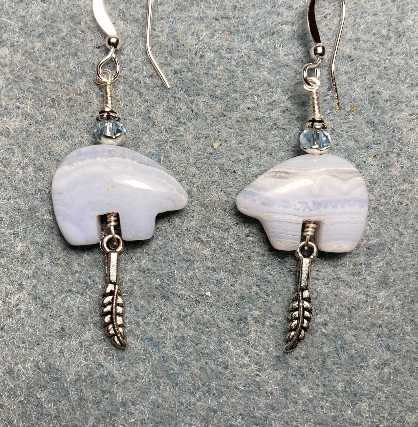 Blue lace agate gemstone Zuni bear fetish bear earrings adorned with light blue crystal beads and tiny silver feather charms.