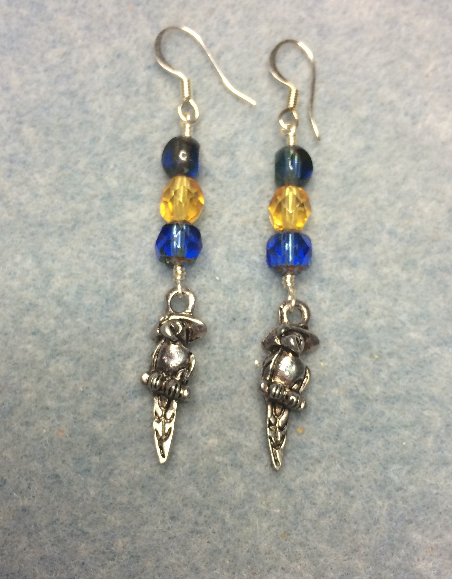 Silver macaw feather earrings adorned with blue and yellow Czech glass beads