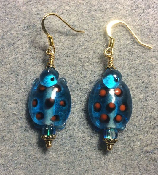 Dark turquoise with orange spots lamp work turtle bead earrings adorned with dark turquoise Czech glass beads.