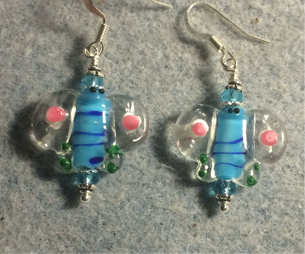 Turquoise and pink lamp work butterfly bead earrings adorned with turquoise Chinese crystal beads.