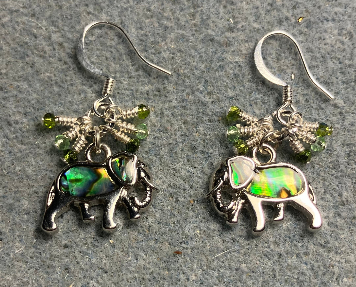 Small silver and abalone elephant charm earrings adorned with tiny dangling green Chinese crystal beads.