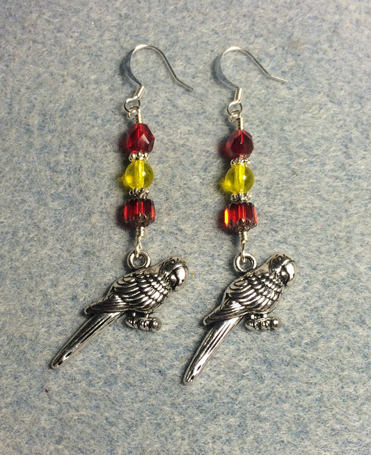 Large silver macaw charm earrings adorned with red and yellow Czech glass beads