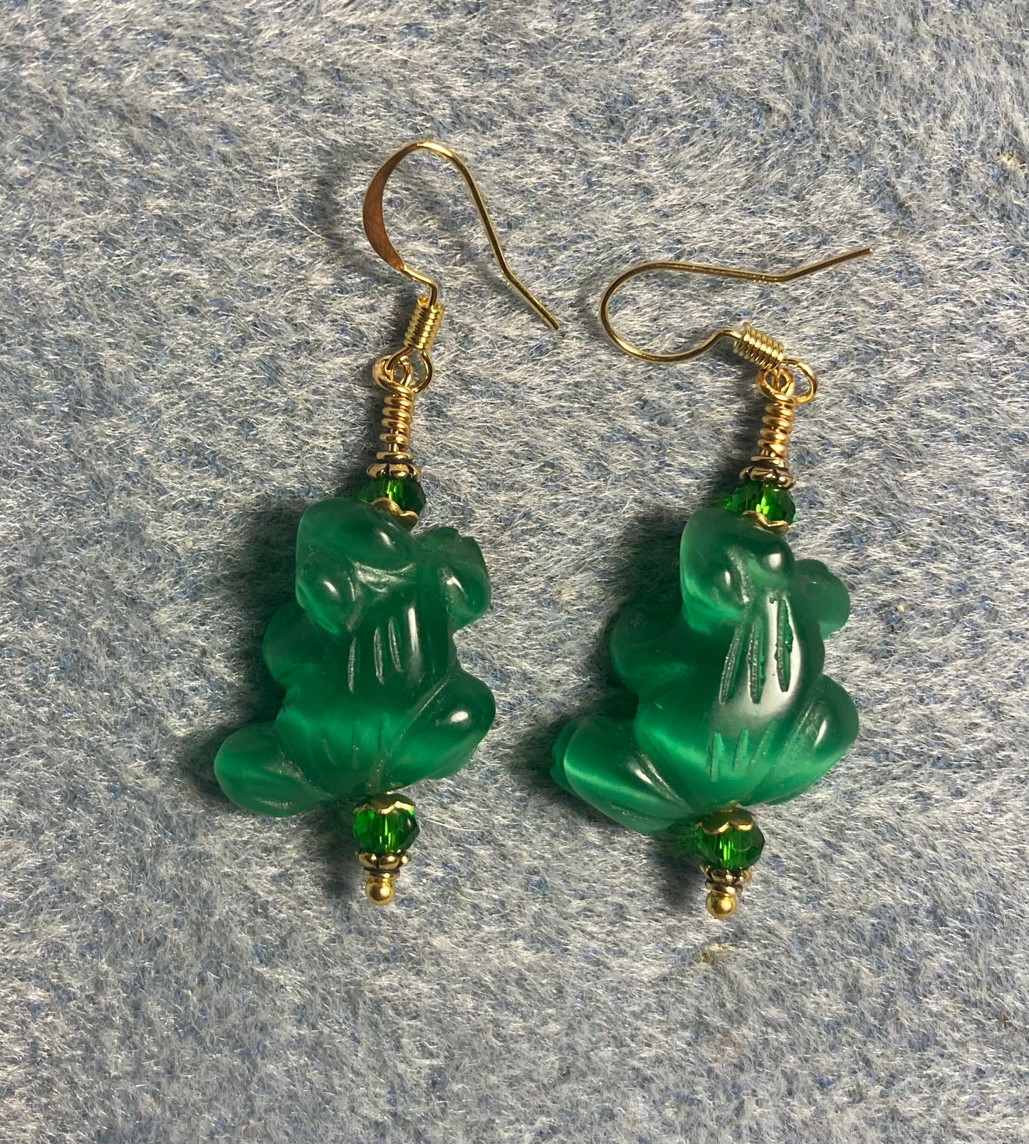 Emerald green fiber optic (cat’s eye) frog bead earrings adorned with emerald green Chinese crystal beads.