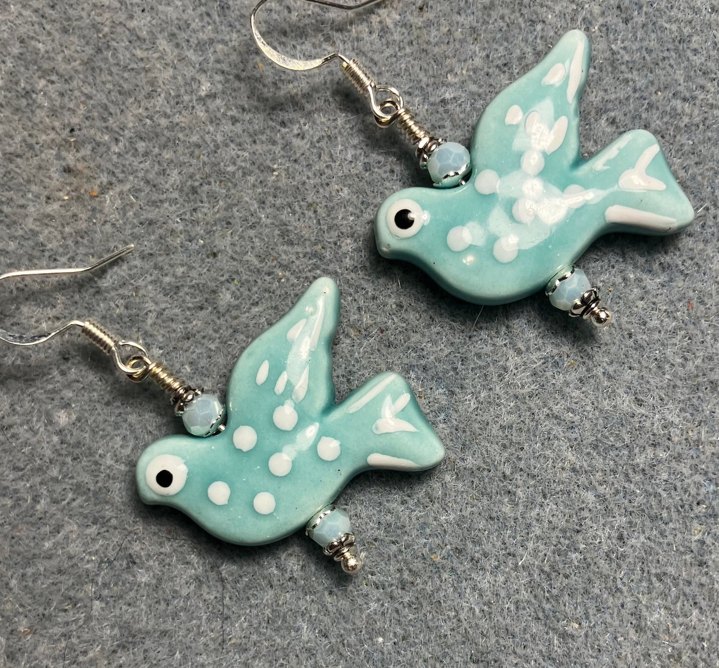 Large light turquoise and white ceramic spotted dove bead earrings adorned with light turquoise Chinese crystal beads.