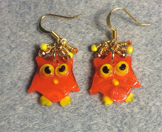 Flat orange and yellow lamp work owl charm earrings adorned with tiny dangling orange and yellow Chinese crystal beads.