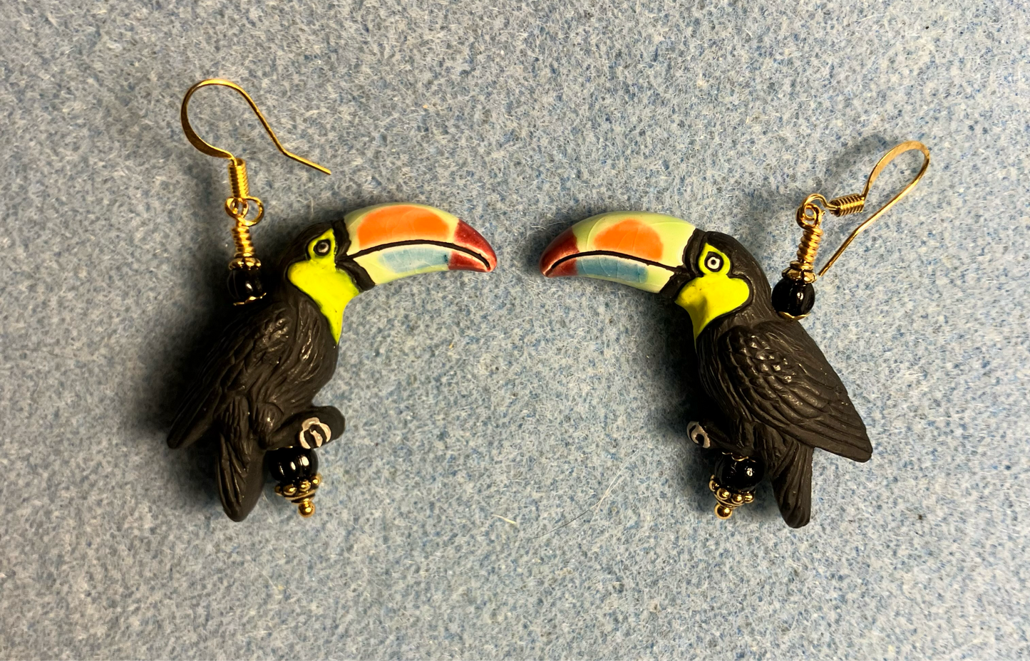 Large black (with colorful beaks) ceramic toucan bead earrings adorned with black Czech glass beads.