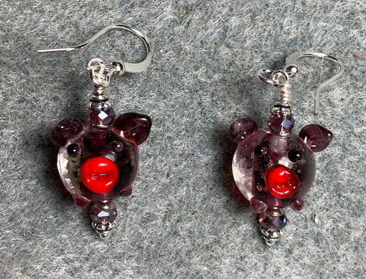 Purple, red, and clear glow in the dark lamp work pig bead earrings adorned with purple Chinese crystal beads.