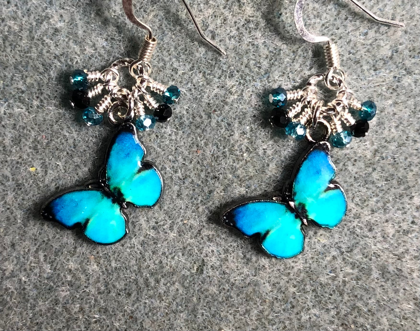 Turquoise and black enamel butterfly charm earrings adorned with tiny dangling turquoise and black Chinese crystal beads.