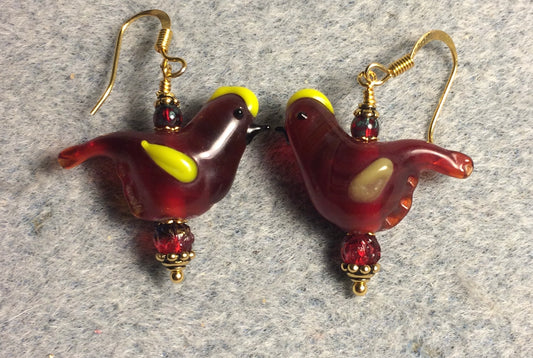 Translucent dark red and yellow lamp work songbird bead earrings adorned with dark red Czech glass beads.