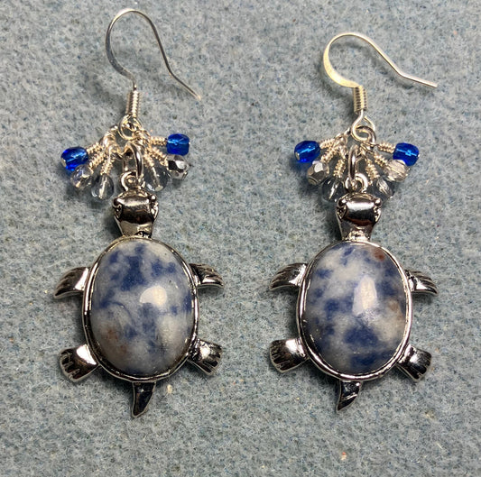 Large silver and blue sodalite gemstone turtle charm earrings adorned with small dangling dark blue, light blue, and silver Czech glass beads.