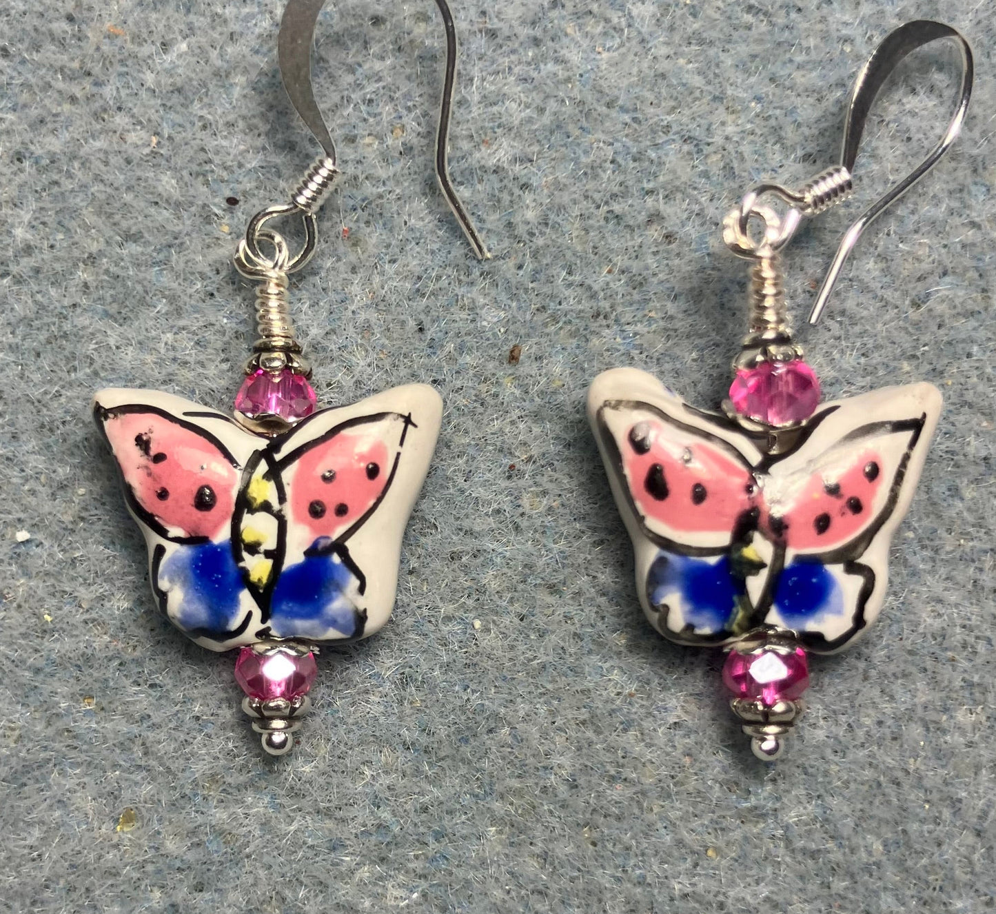 Hot pink and blue ceramic butterfly bead earrings adorned with hot pink Chinese crystal beads.