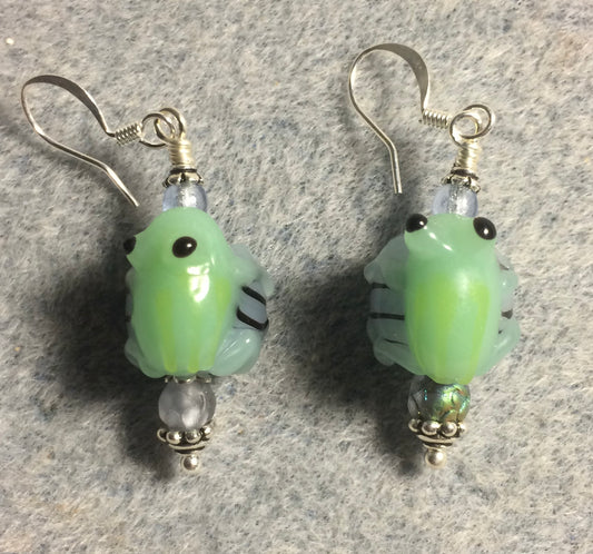 Green and light blue lamp work frog bead earrings adorned with light blue Czech glass beads.