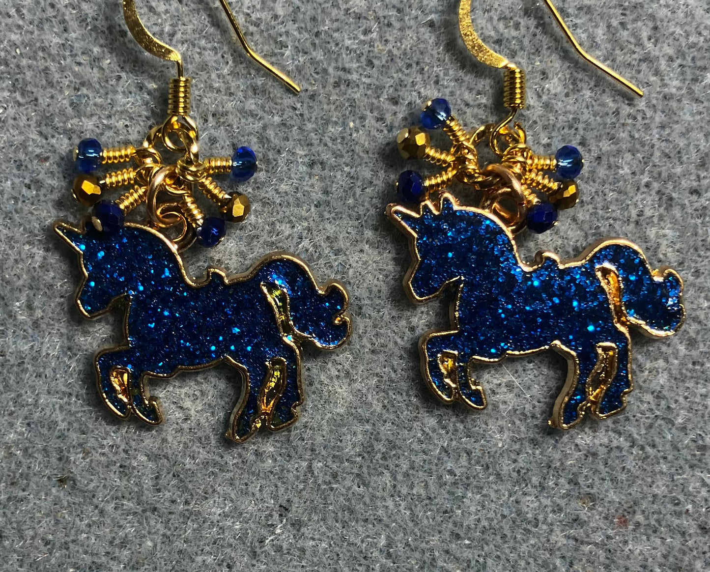 Dark blue and gold enamel sparkly unicorn charm earrings adorned with tiny dangling dark blue and gold Chinese crystal beads.