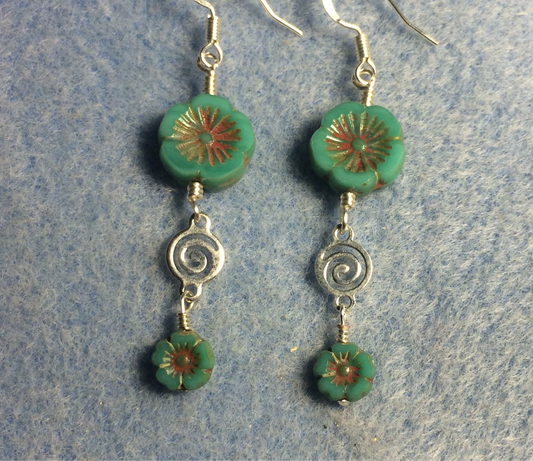 Opaque turquoise green Czech glass pansy bead earrings adorned with silver swirly connectors and tiny turquoise green Czech glass pansy beads.