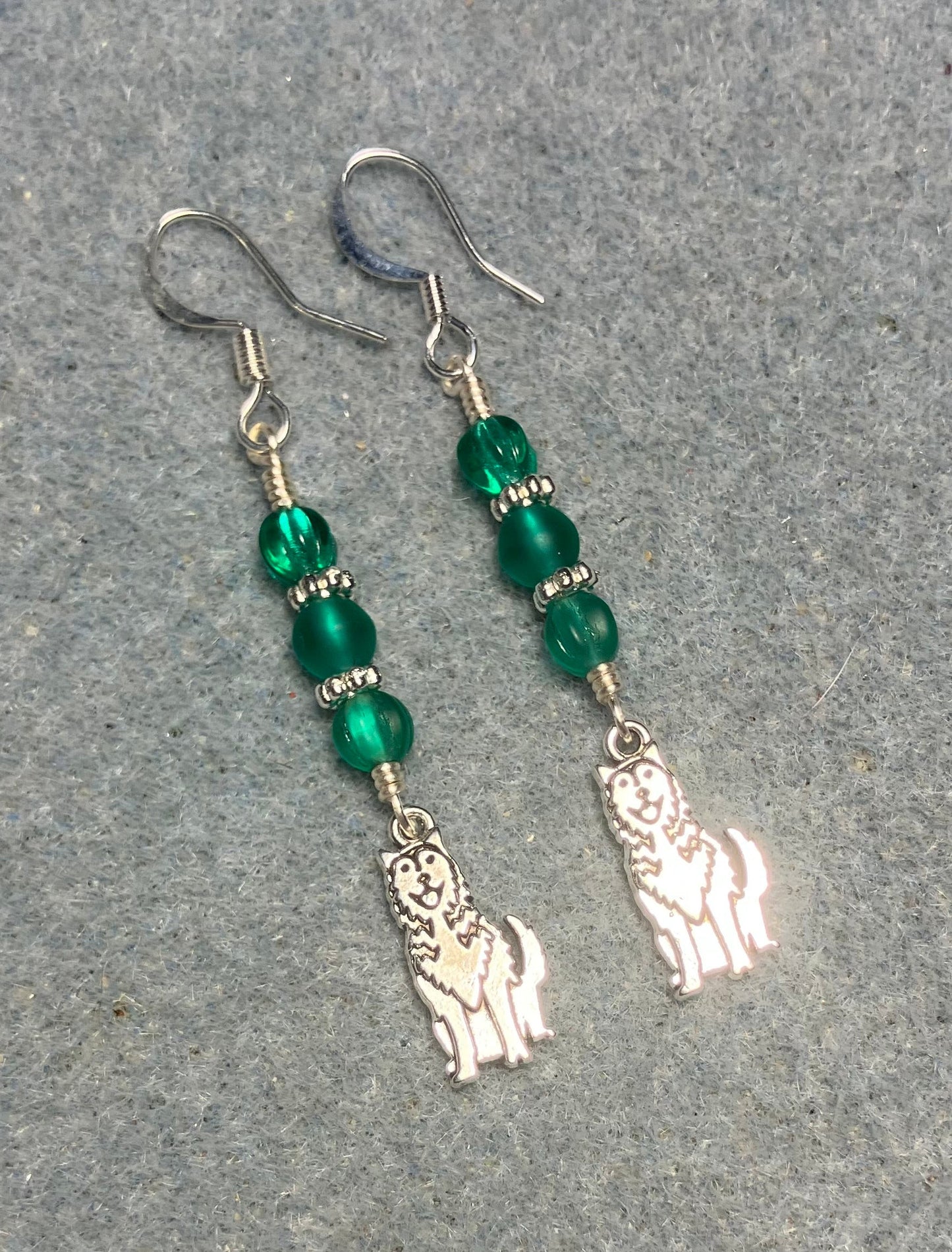 Small silver husky charm earrings adorned with small teal Czech glass beads.