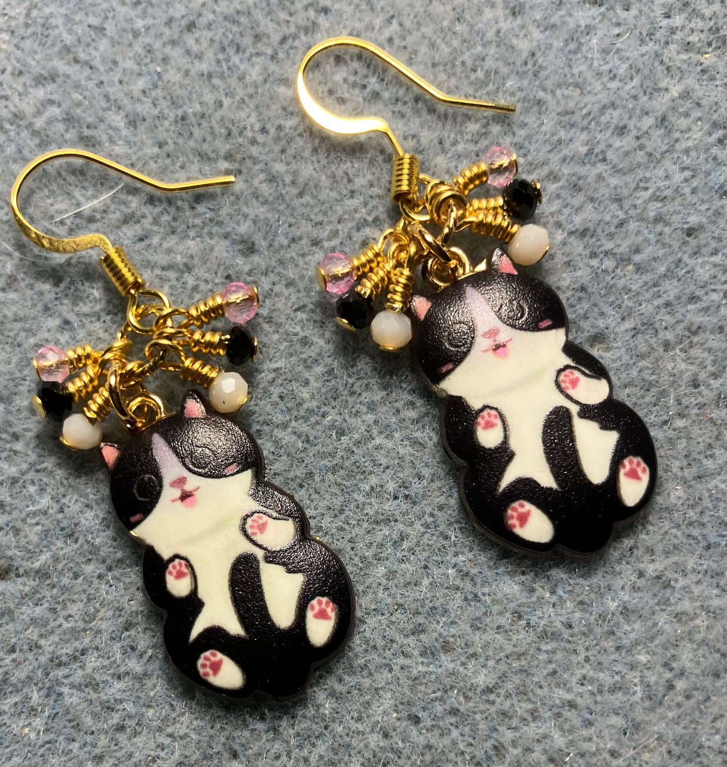 Black, white, and pink enamel cat charm earrings adorned with tiny dangling black, white, and pink Chinese crystal beads.