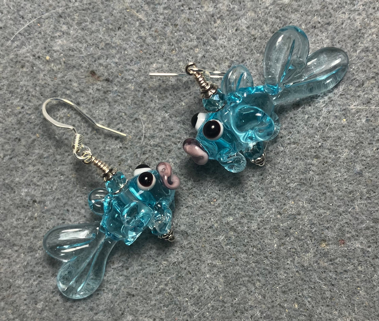 Translucent light turquoise lamp work fish bead earrings adorned with light turquoise Chinese crystal beads.
