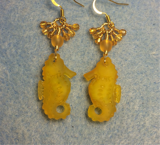 Amber sea glass seahorse pendant bead earrings adorned with amber Czech glass beads and small dangling amber Czech glass beads.