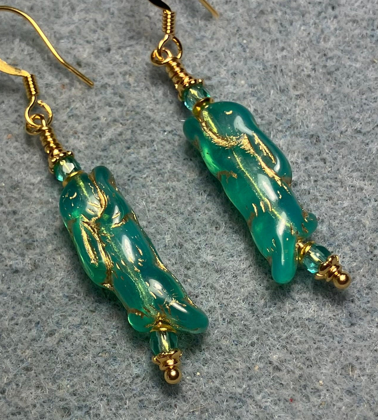 Small teal (with gold inlay) Czech glass bunny rabbit bead earrings adorned with small teal Czech glass beads.