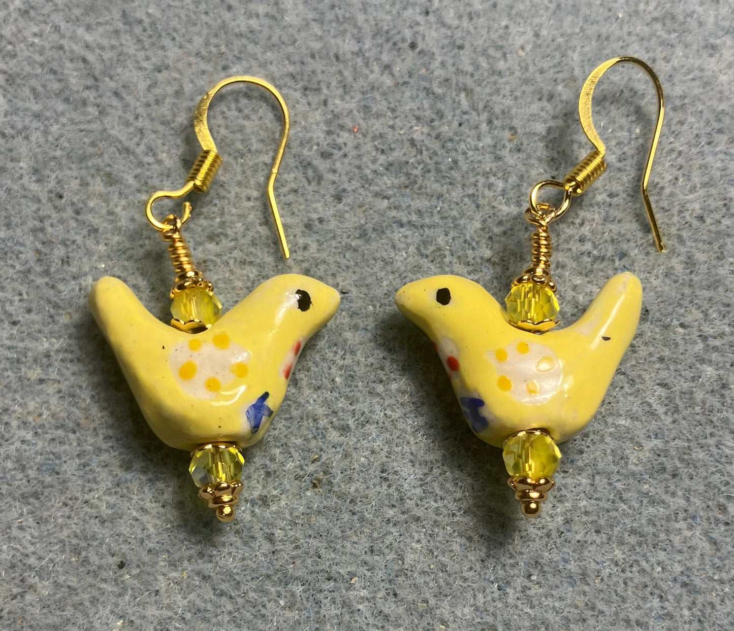 Small yellow, white, and blue ceramic bird bead earrings adorned with yellow Chinese crystal beads.