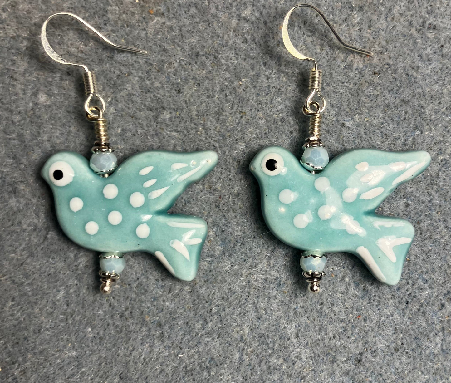 Large light turquoise and white ceramic spotted dove bead earrings adorned with light turquoise Chinese crystal beads.