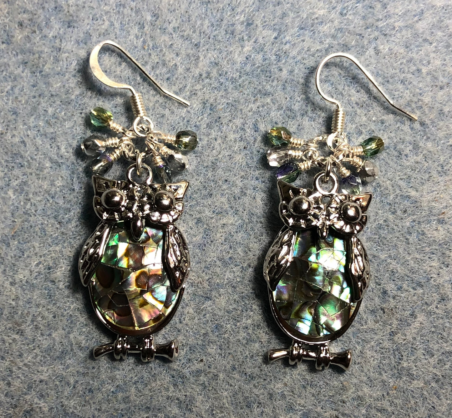 Large silver and abalone owl charm earrings adorned with small dangling light green and silver Czech glass beads.