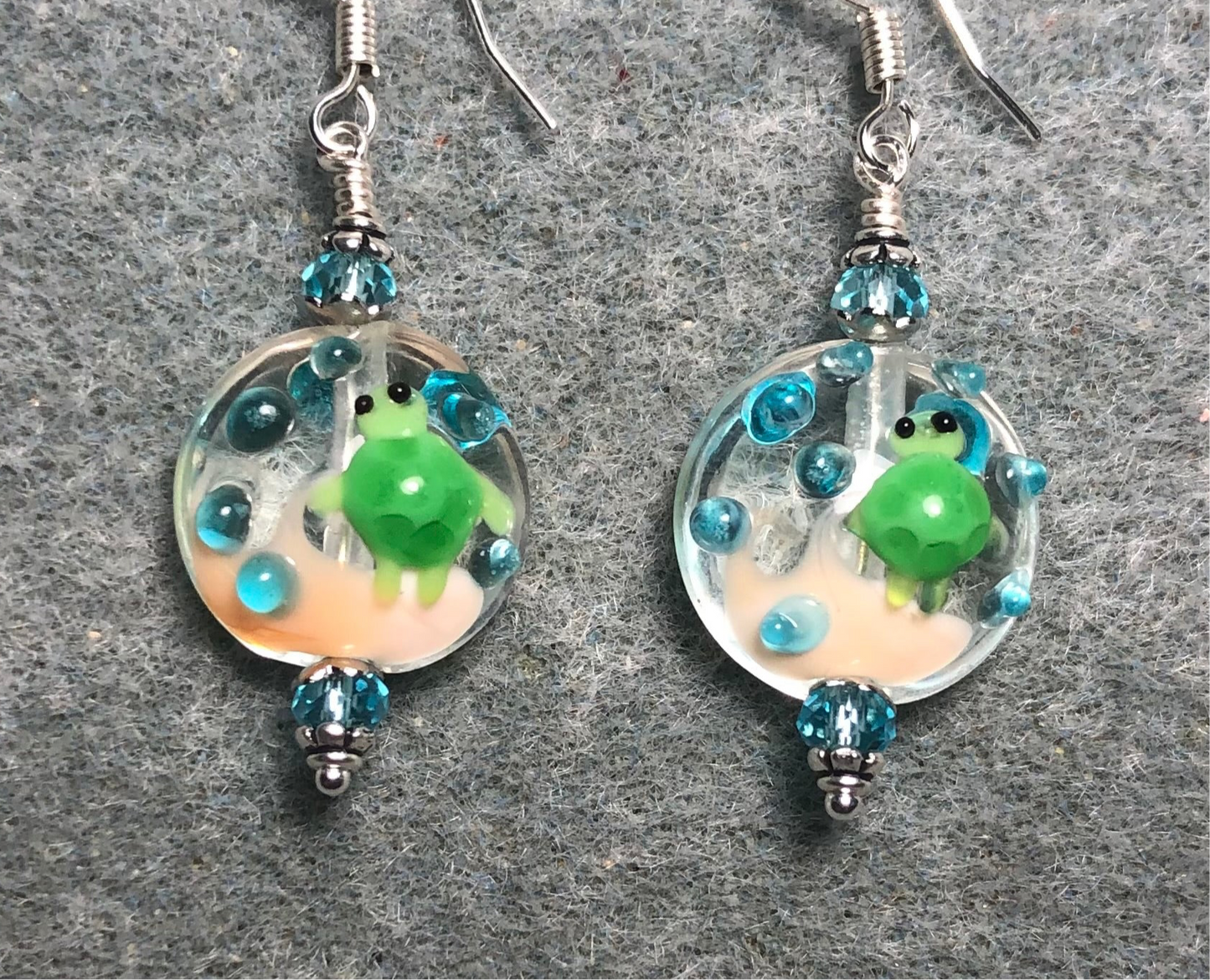 Clear, green, and turquoise lamp work turtle bead earrings adorned with turquoise Chinese crystal beads.