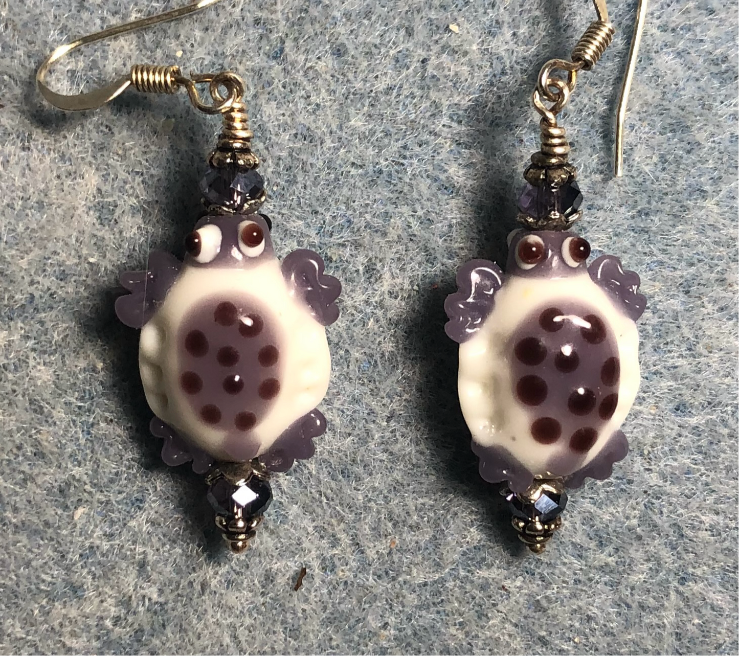 Purple and white lamp work spotted turtle bead earrings adorned with purple Chinese crystal beads.