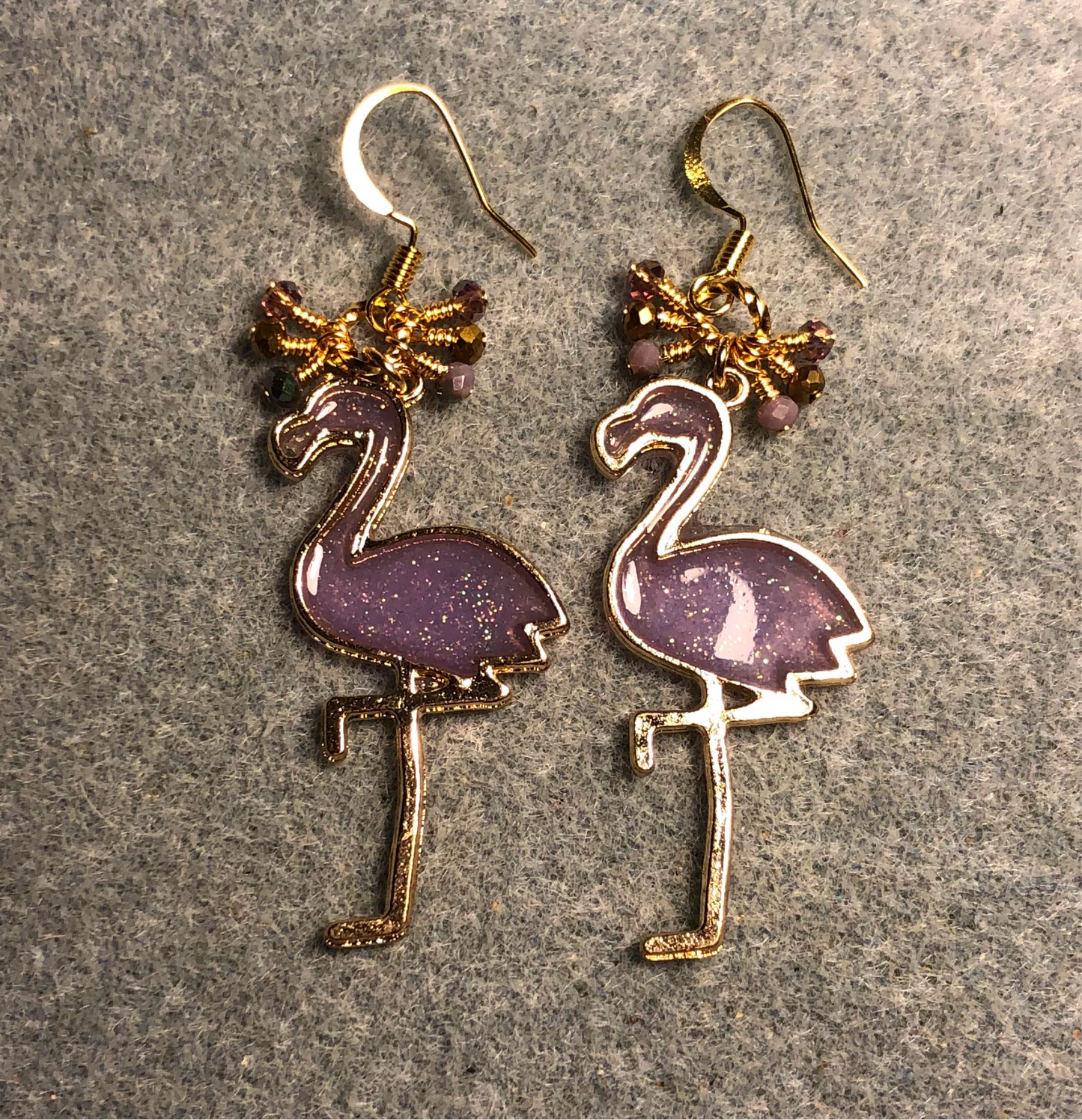 Large gold and purple resin flamingo charm earrings adorned with tiny dangling purple and gold Chinese crystal beads.