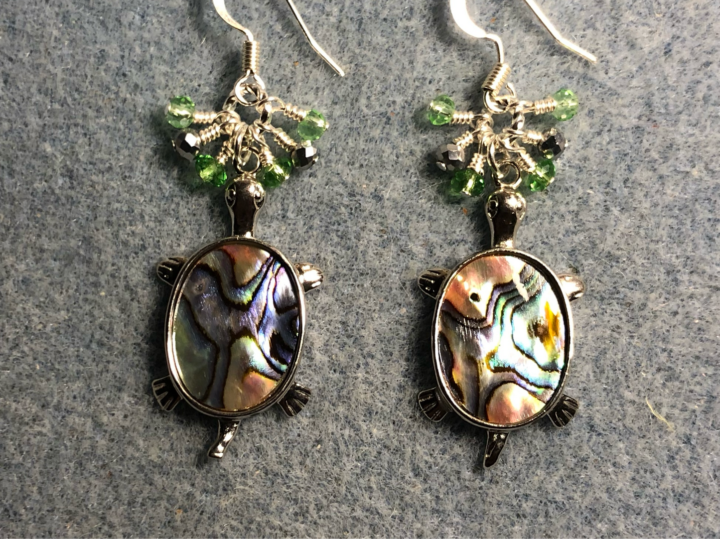 Silver and abalone turtle charm earrings adorned with small dangling light green and silver Chinese crystal beads.