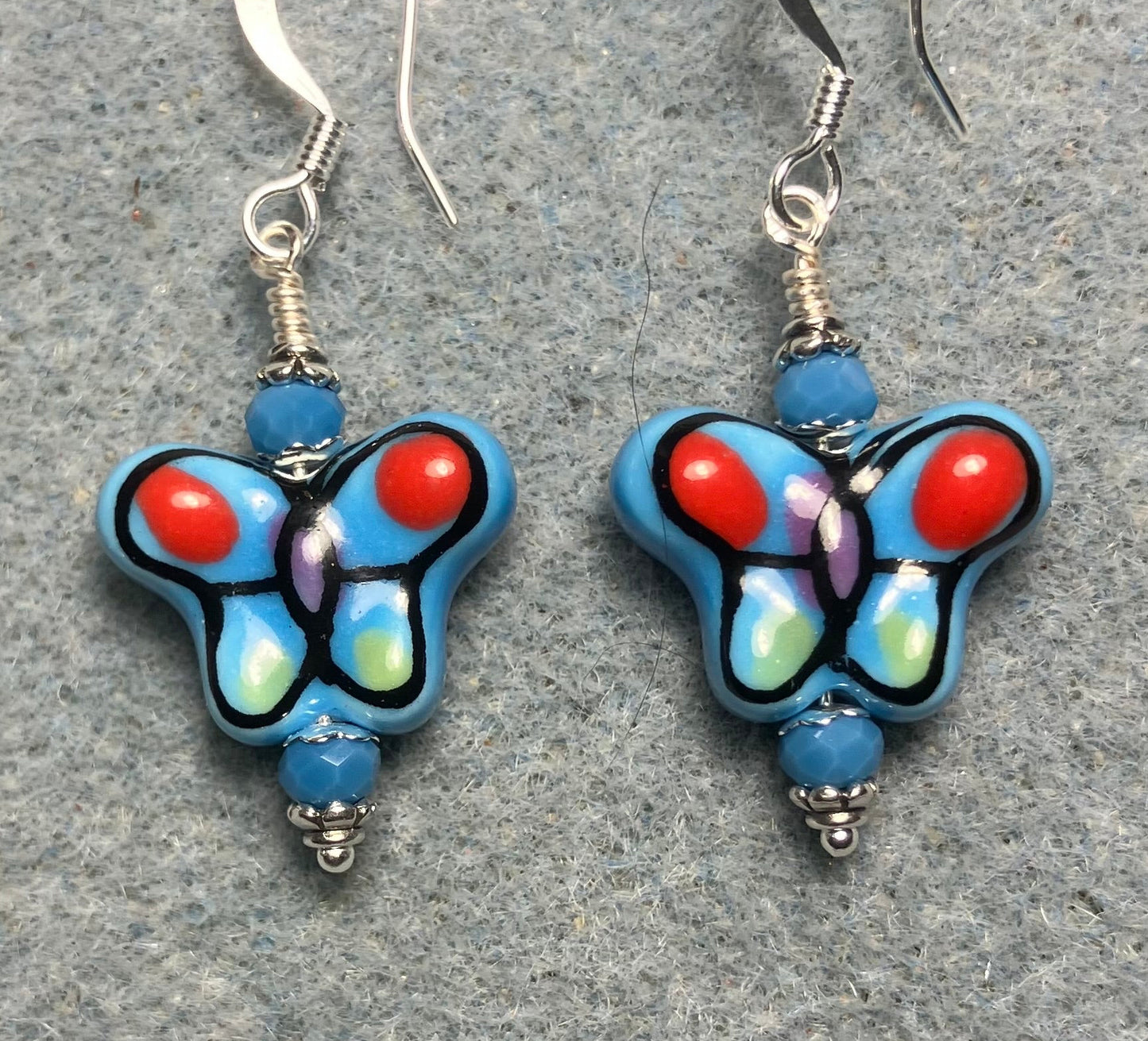 Blue and red ceramic butterfly bead earrings adorned with blue Chinese crystal beads.