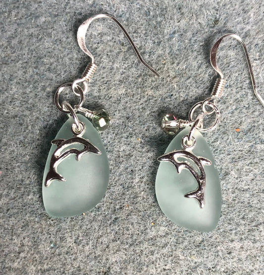 Small light green sea glass pendant bead earrings adorned with small silver dolphin charms and small light green Chinese crystal beads.