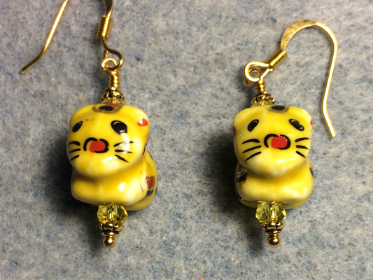 Yellow, black, and red ceramic tiger bead earrings adorned with yellow Chinese crystal beads.