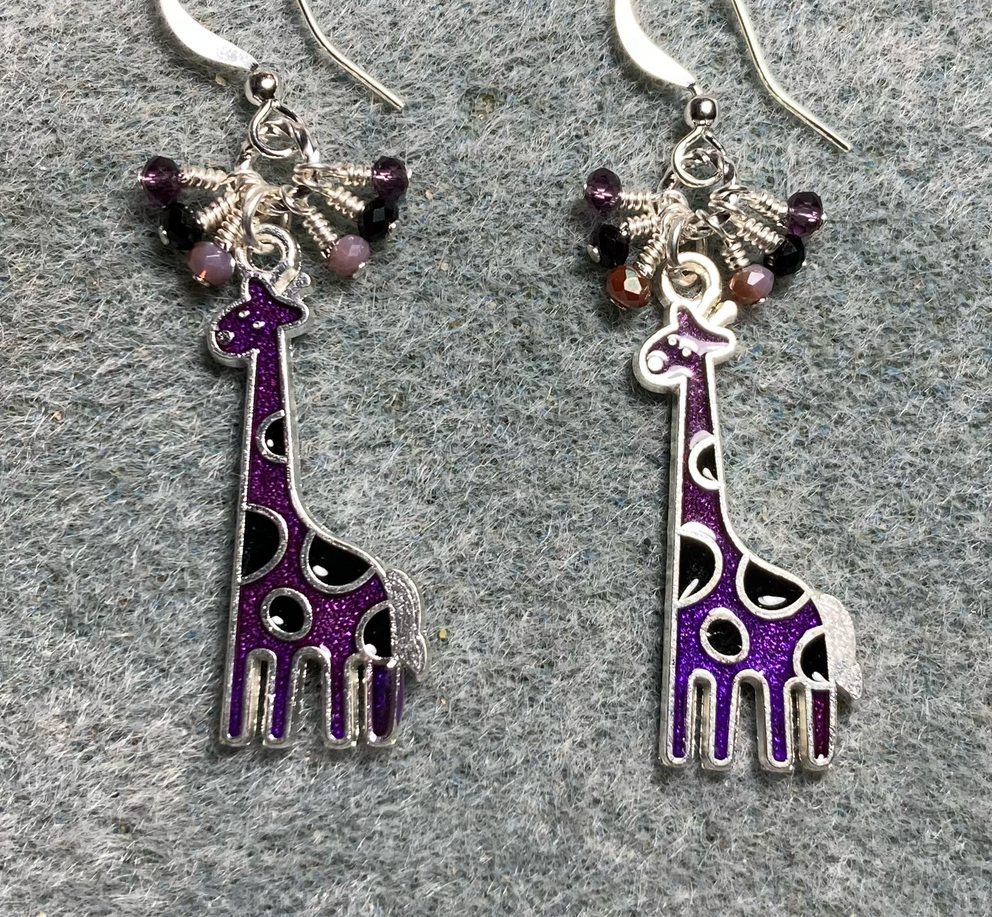 Purple and black enamel spotted giraffe charm earrings adorned with tiny dangling purple and black Chinese crystal beads.