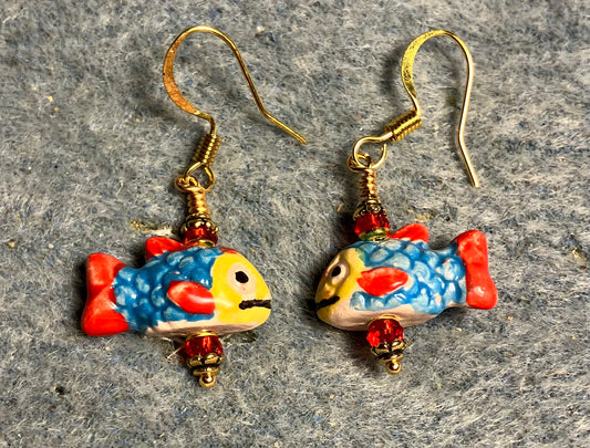 Small turquoise, red, and yellow ceramic fish bead earrings adorned with red Chinese crystal beads.