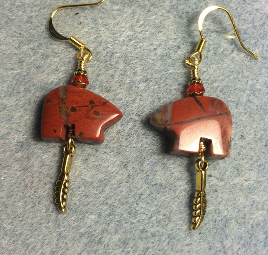 Red poppy jasper gemstone Zuni bear fetish bear earrings adorned with red crystal beads and tiny gold feather charms.